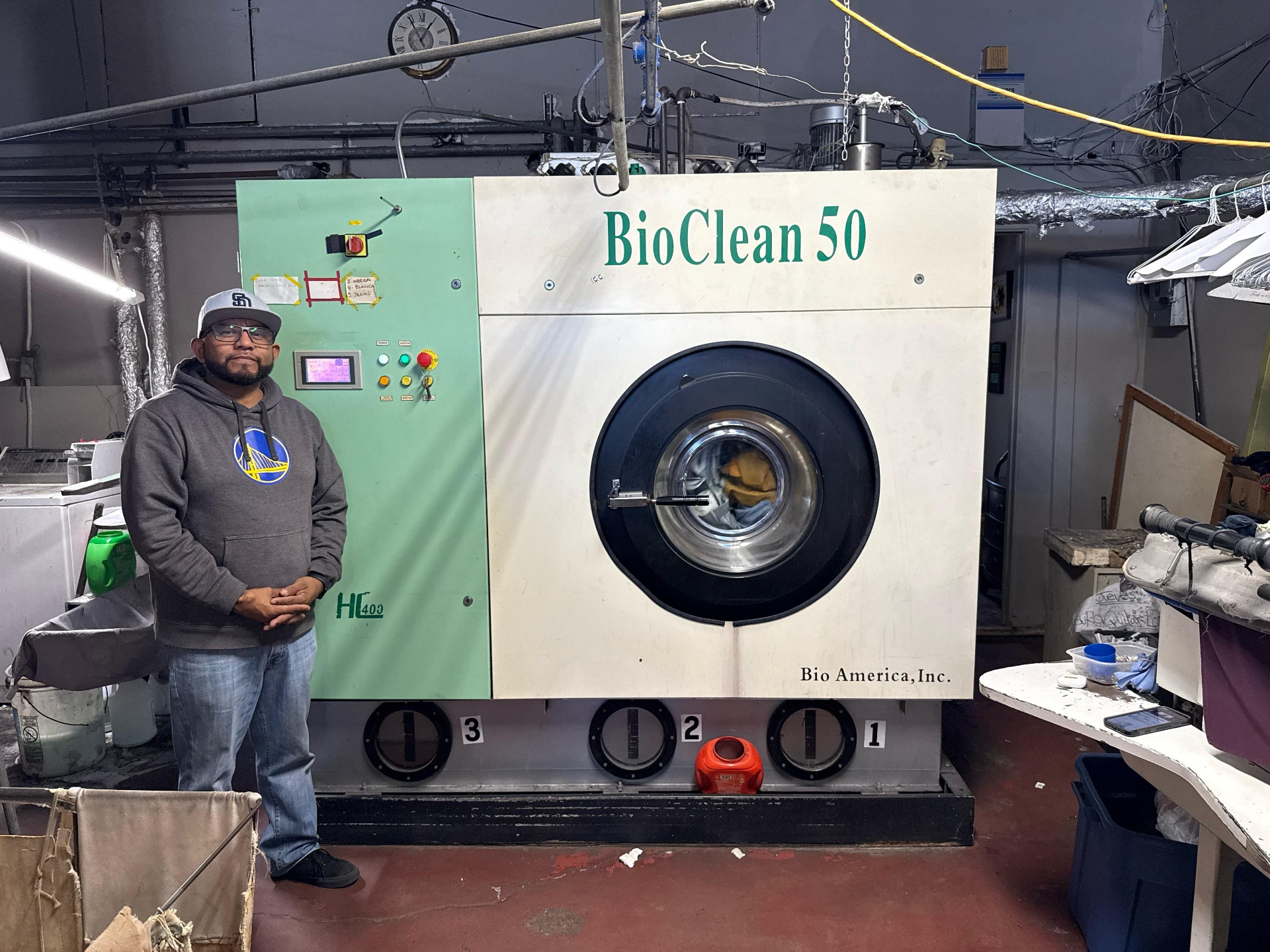 Julio Cesar Piñon standing beside the BioClean 50 dry cleaning machine